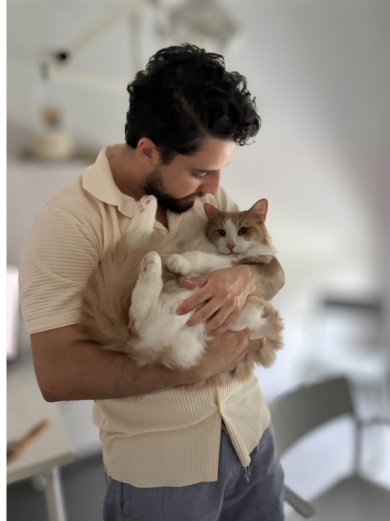 Grundaren håller sin katt i famnen